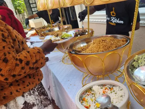 Uniformed service staff attending a hot buffet line at a Kims Kitchen corporate event